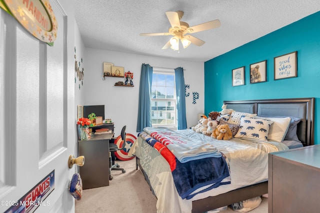 carpeted bedroom featuring a ceiling fan and a textured ceiling