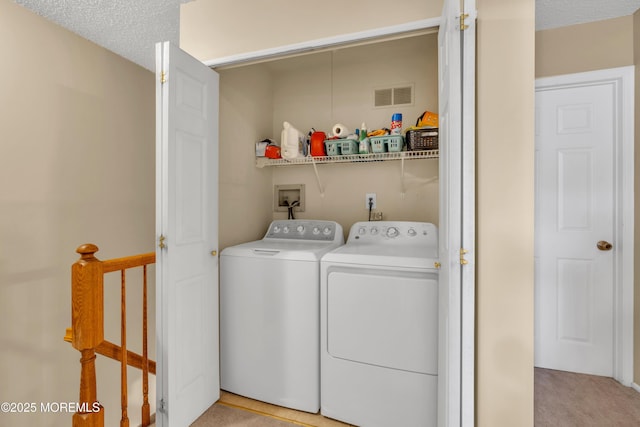 washroom featuring a textured ceiling, laundry area, independent washer and dryer, and visible vents