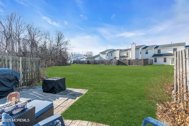 view of yard with a fenced backyard, a residential view, and a patio