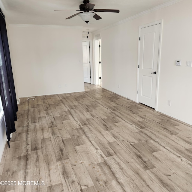 empty room with ceiling fan, ornamental molding, and light wood-type flooring