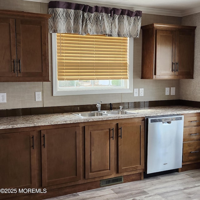 kitchen featuring light wood finished floors, visible vents, dishwasher, crown molding, and a sink