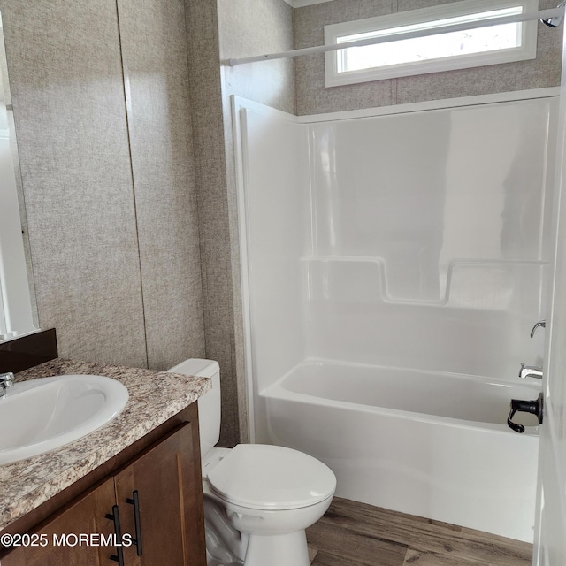 full bath with shower / bathing tub combination, vanity, toilet, and wood finished floors