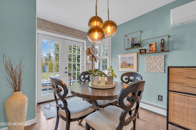 dining area with baseboards, french doors, baseboard heating, a wall mounted AC, and light wood finished floors