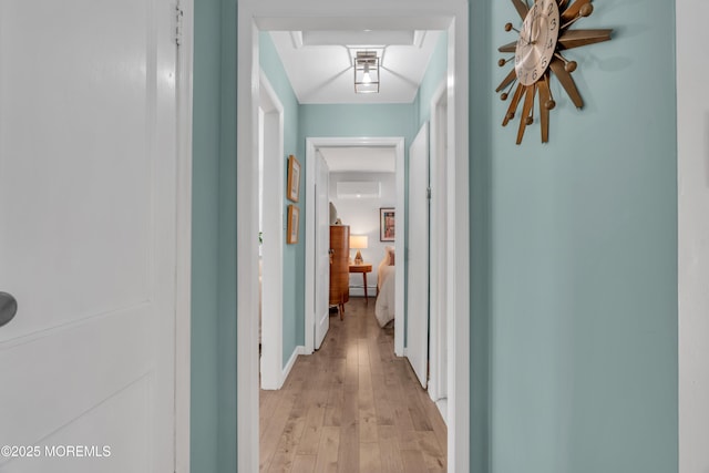 hall with an AC wall unit and light wood-type flooring