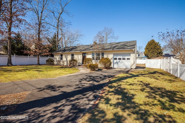 view of front of home featuring a garage, driveway, a front yard, and fence private yard