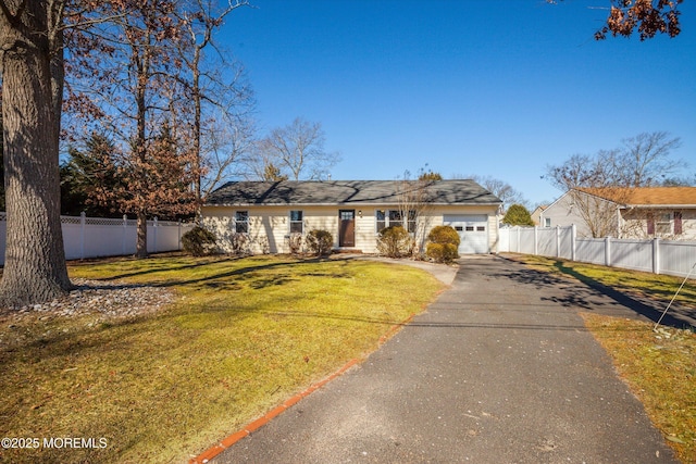 view of front of home featuring a garage, aphalt driveway, a front yard, and fence