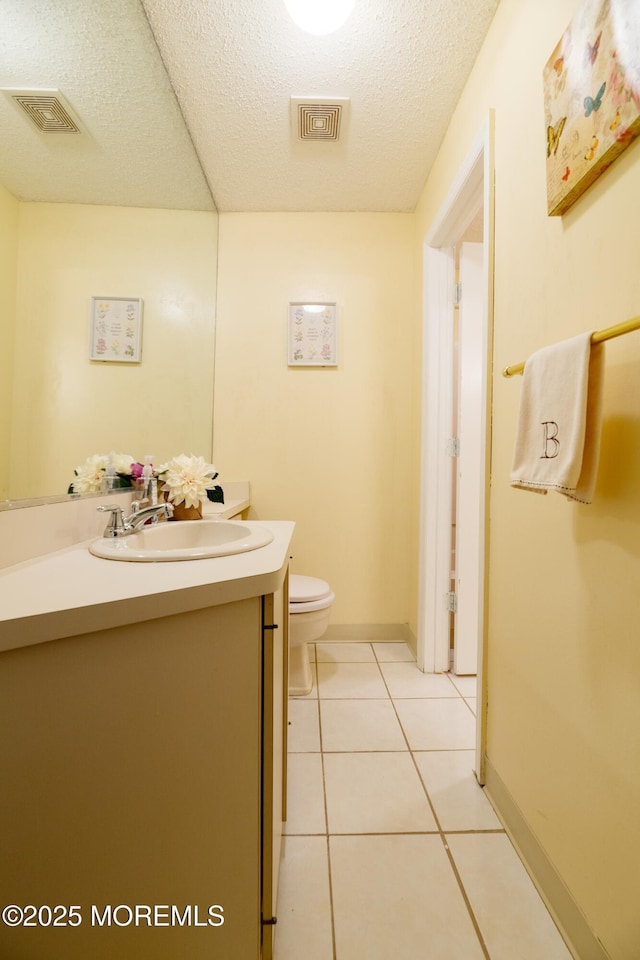 bathroom with a textured ceiling, vanity, tile patterned flooring, and visible vents