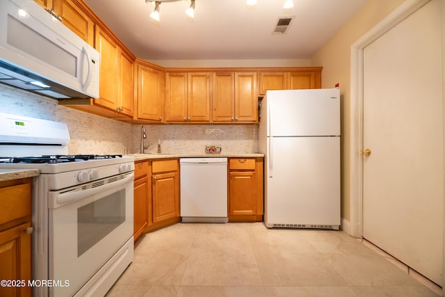 kitchen featuring visible vents, decorative backsplash, brown cabinetry, a sink, and white appliances