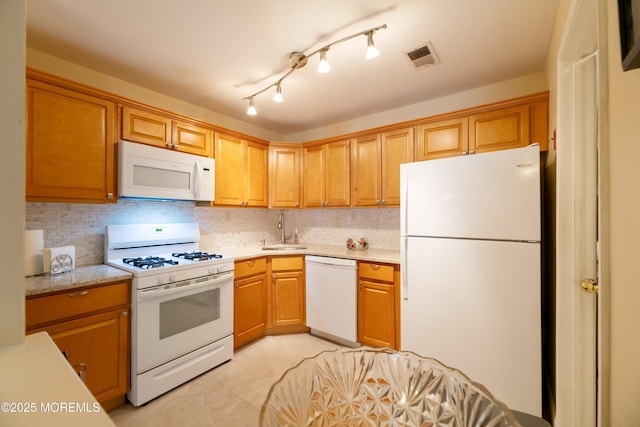 kitchen with light stone counters, visible vents, backsplash, a sink, and white appliances