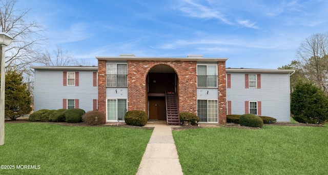 view of front of home featuring a front lawn and brick siding