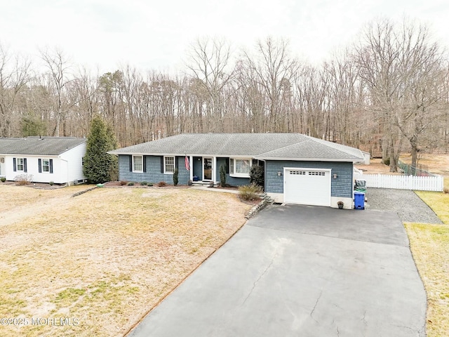 ranch-style home with a garage, driveway, and fence