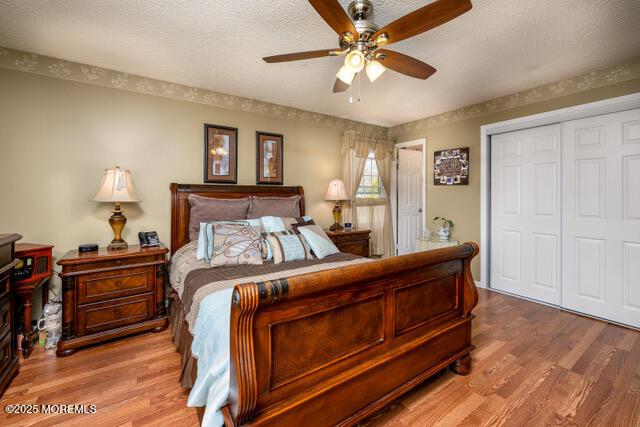 bedroom with a textured ceiling, a closet, and wood finished floors