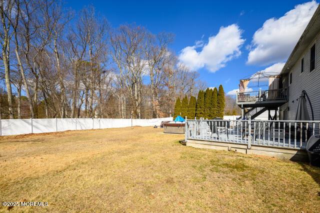 view of yard with stairs, a fenced backyard, and a wooden deck