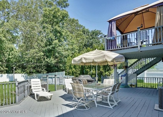 wooden deck with outdoor dining area and fence