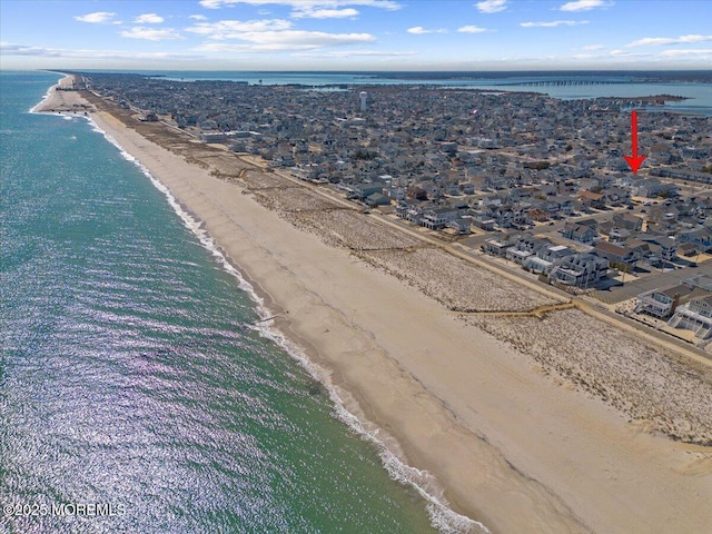 birds eye view of property featuring a beach view and a water view