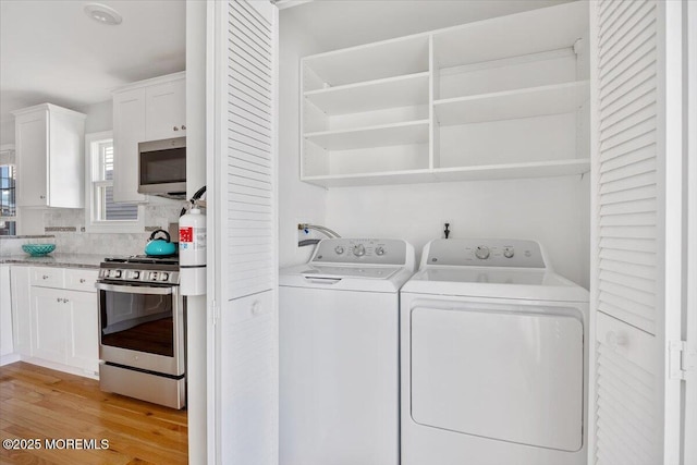 washroom featuring light wood-style flooring, laundry area, and washer and clothes dryer