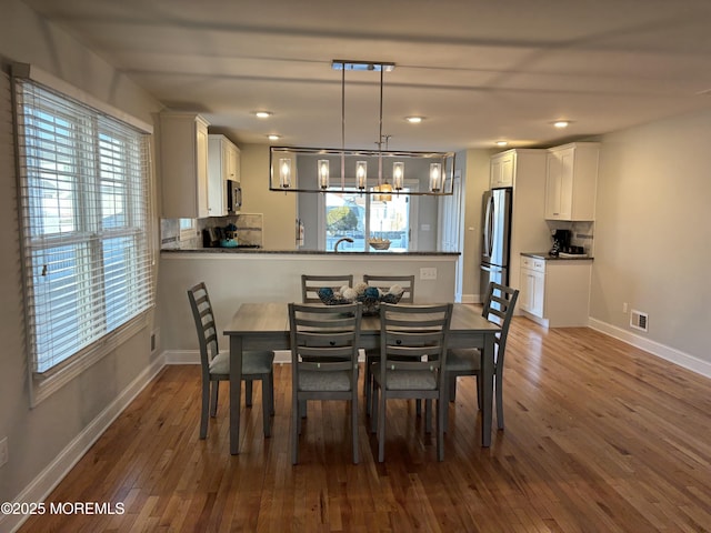 dining space featuring a notable chandelier, plenty of natural light, and hardwood / wood-style floors