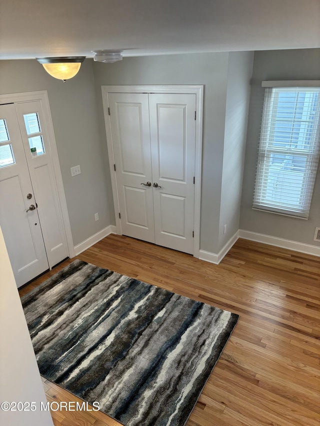 foyer featuring baseboards and light wood finished floors