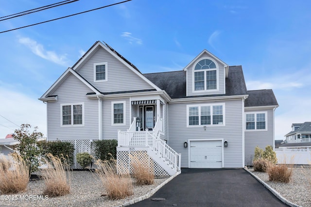 view of front of home with aphalt driveway, fence, and an attached garage