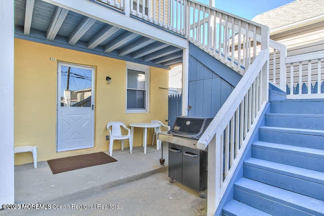 property entrance with a patio and stucco siding