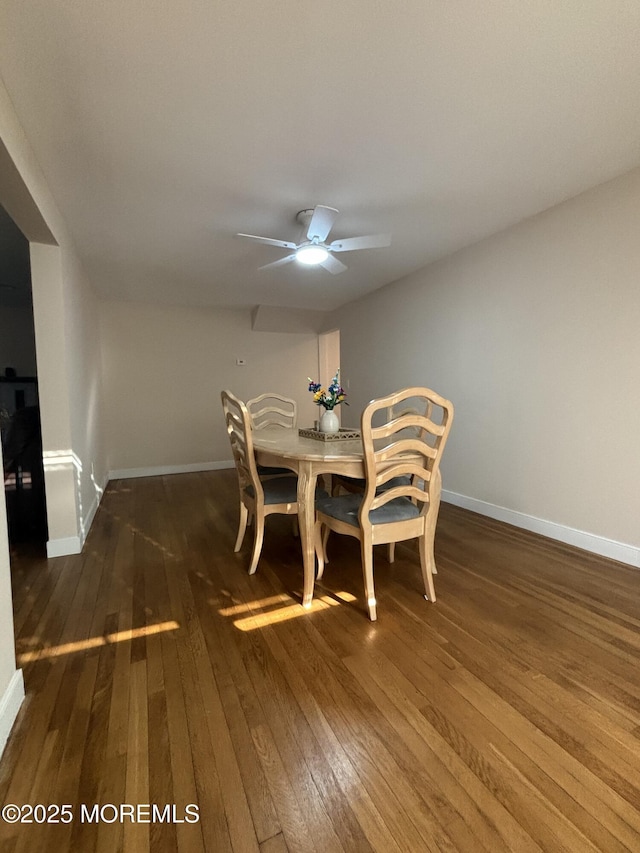 unfurnished dining area featuring hardwood / wood-style flooring, ceiling fan, and baseboards