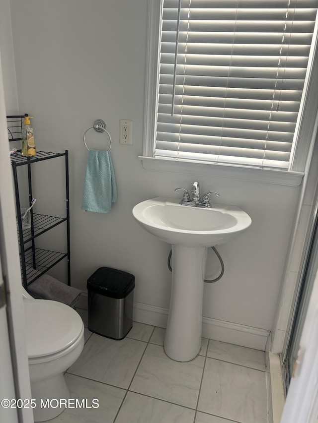 bathroom featuring a sink, toilet, and baseboards