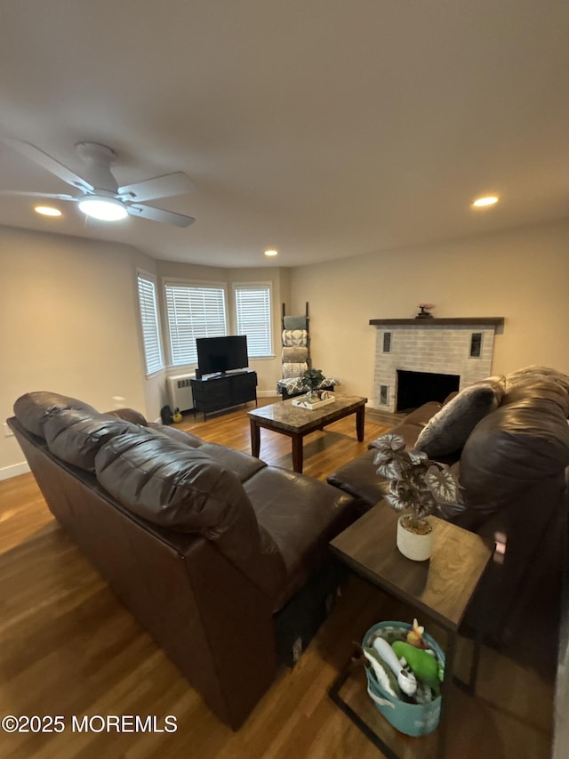 living area featuring ceiling fan, a fireplace, wood finished floors, and recessed lighting