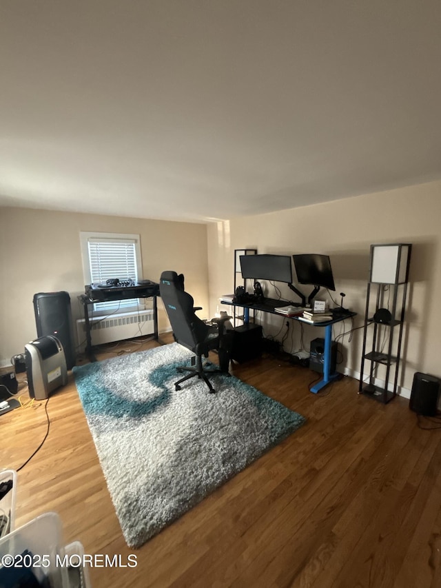 home office with baseboards and wood finished floors