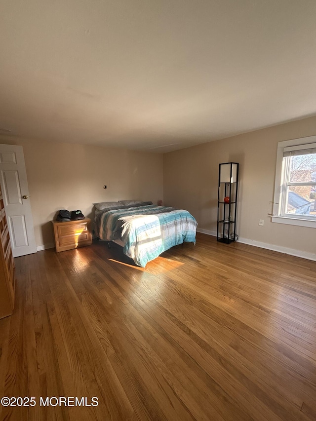 unfurnished bedroom with baseboards and dark wood finished floors