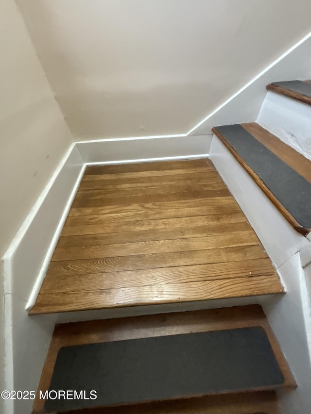 bonus room with stairs and wood finished floors