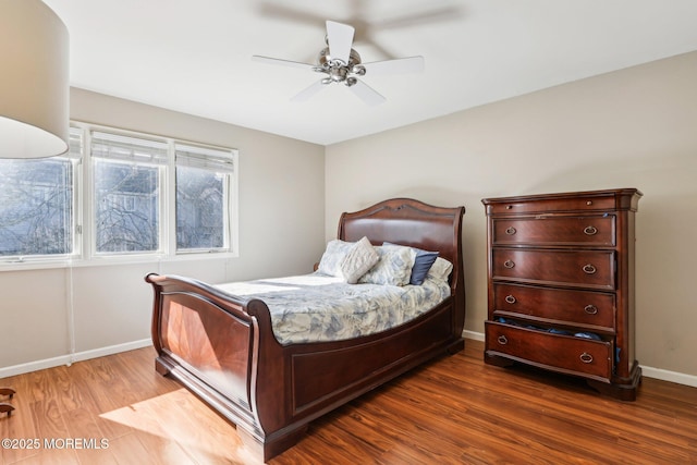 bedroom featuring wood finished floors, a ceiling fan, and baseboards