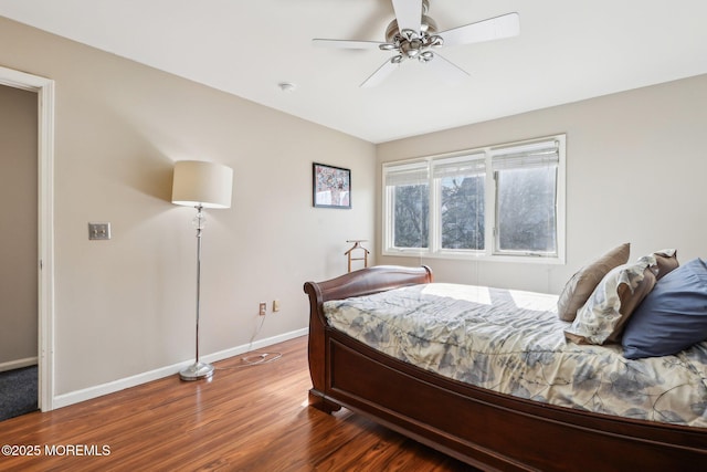 bedroom with a ceiling fan, baseboards, and wood finished floors