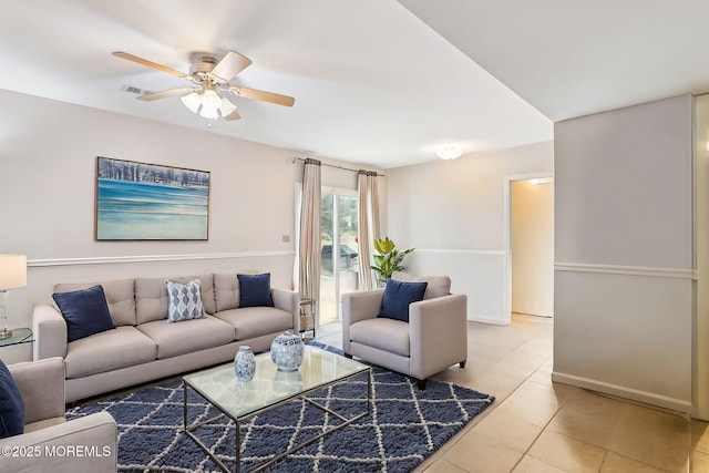 living room featuring light tile patterned floors, ceiling fan, visible vents, and baseboards