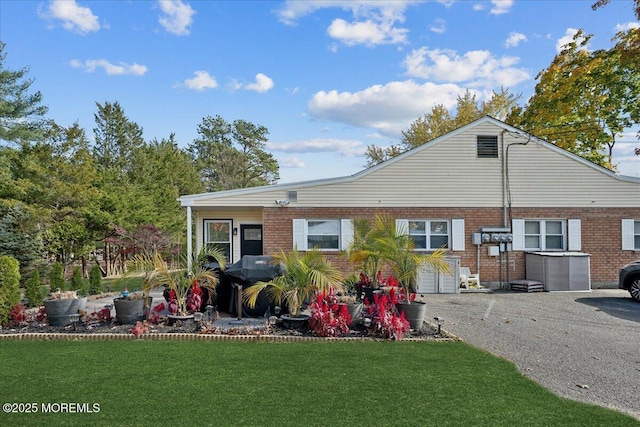 rear view of house with a yard and brick siding