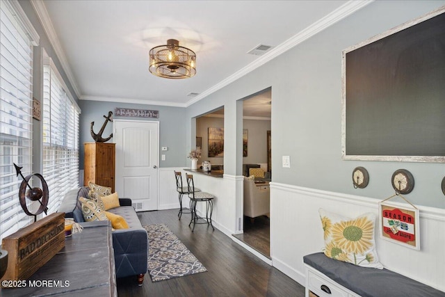 interior space with visible vents, dark wood finished floors, and ornamental molding