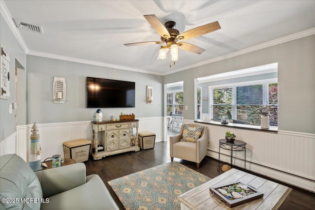 living area featuring a wainscoted wall, visible vents, baseboard heating, and wood finished floors