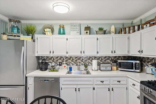 kitchen featuring stainless steel appliances, a sink, white cabinetry, and crown molding