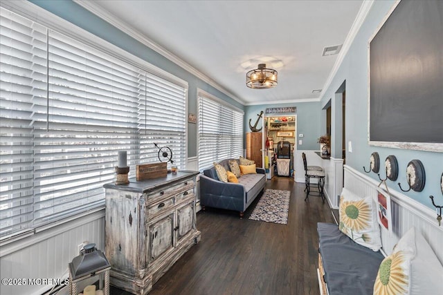 living area featuring dark wood-type flooring, wainscoting, visible vents, and ornamental molding