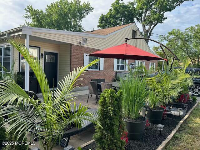 rear view of house featuring a patio and brick siding