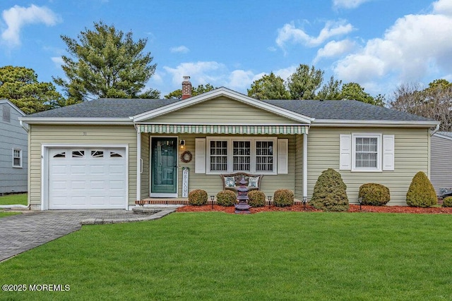 single story home with a garage, a shingled roof, decorative driveway, a front lawn, and a chimney