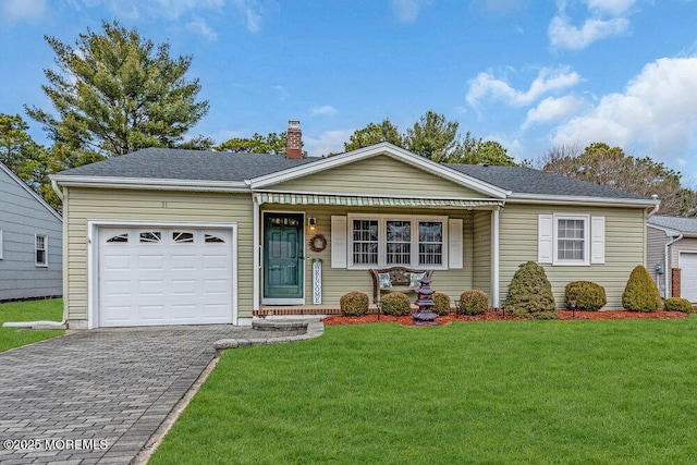 ranch-style home with an attached garage, a shingled roof, decorative driveway, a chimney, and a front yard