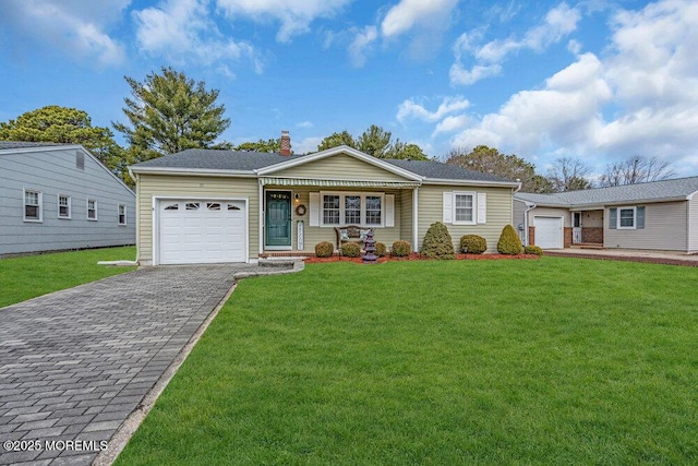 ranch-style home featuring a front lawn, decorative driveway, a chimney, and an attached garage