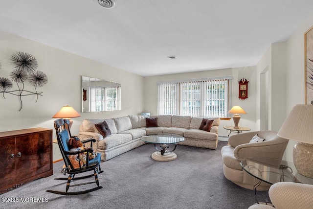 carpeted living area featuring a healthy amount of sunlight, a baseboard heating unit, and visible vents