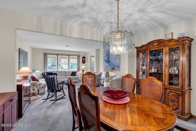 dining room featuring carpet and a notable chandelier