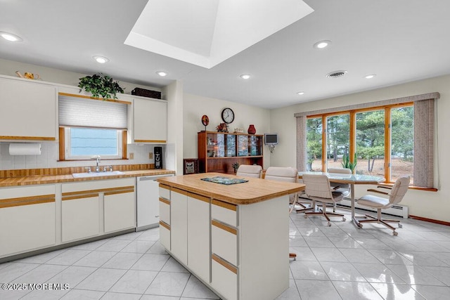 kitchen featuring visible vents, backsplash, white cabinetry, a sink, and dishwasher