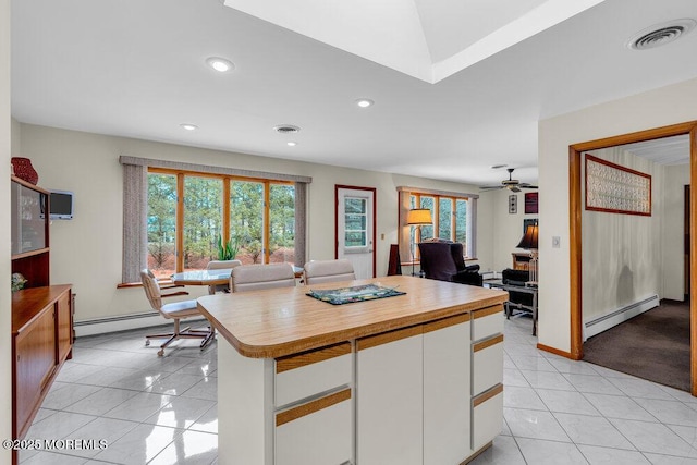 kitchen with open floor plan, baseboard heating, visible vents, and white cabinetry