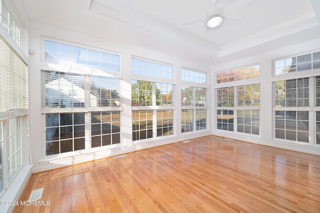 unfurnished sunroom featuring ceiling fan, visible vents, and a raised ceiling