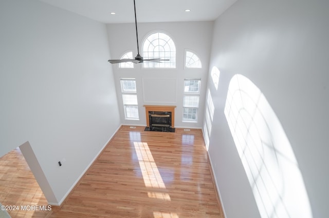 unfurnished living room featuring plenty of natural light, light wood-style flooring, and baseboards