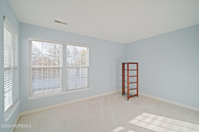 carpeted spare room with baseboards and visible vents