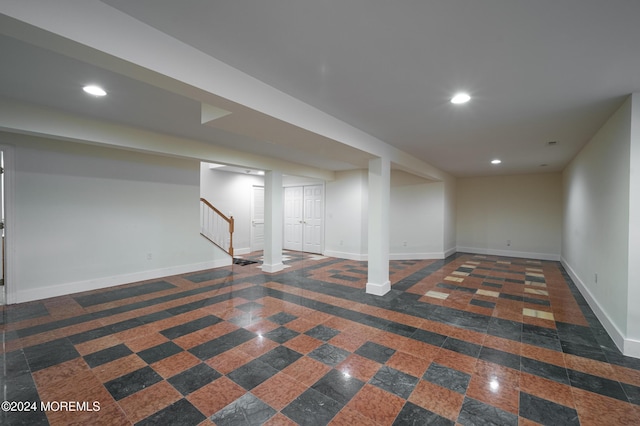 finished basement with baseboards, stairway, granite finish floor, and recessed lighting